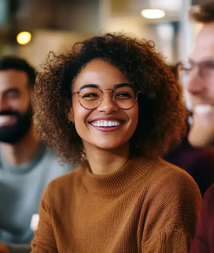 A woman smiling with blurry figures of two males on both sides-1